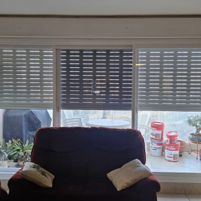 תריסי אלומיניום סגורים על חלון גדול בסלון