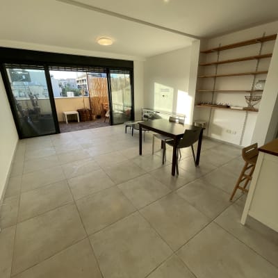 חדר עם שולחן וכיסאות, מדפים ריקים על הקיר