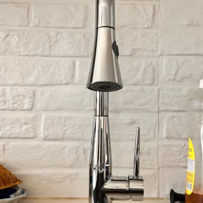 ברז מטבח נירוסטה על רקע קיר לבנים