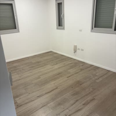 חדר ריק עם רצפת עץ נקייה וקירות לבנים