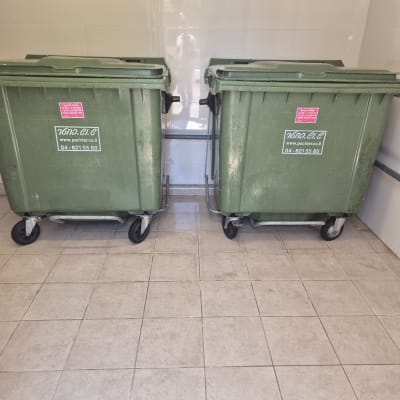 שני פחי אשפה ירוקים על רצפת אריחים