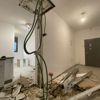 חוטי חשמל חשופים, קיר מפורק, פסולת בנייה על הרצפה