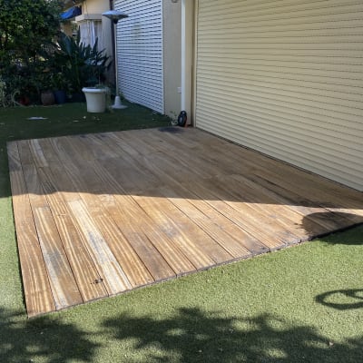 דק עץ על דשא סינטטי ליד דלת תריס