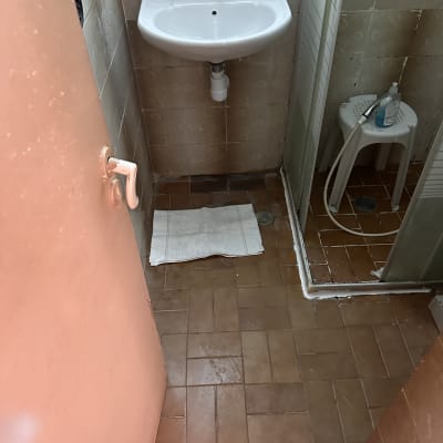 כיור רחצה לבן תלוי וסיפון בחדר רחצה