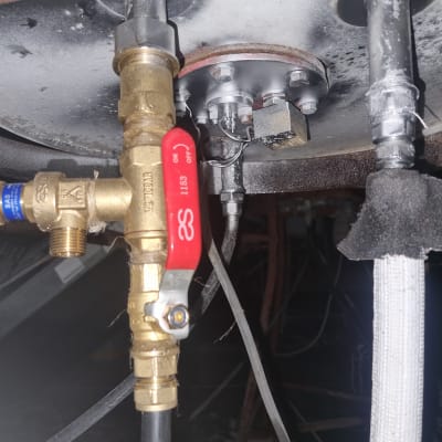 שסתום פליז עם ידית אדומה בצינור דוד שמש