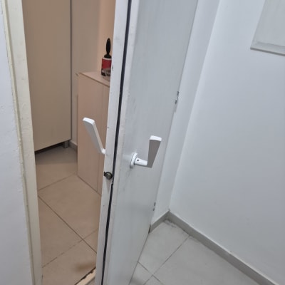 דלת פתוחה עם ידית לבנה ומנעול