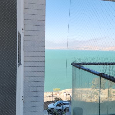 רשת יונים מותקנת במרפסת עם נוף לים