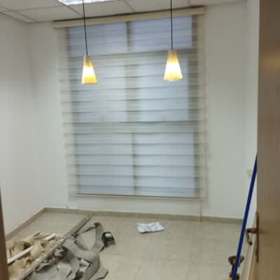 חדר עם וילון, כלים וחומרים על הרצפה