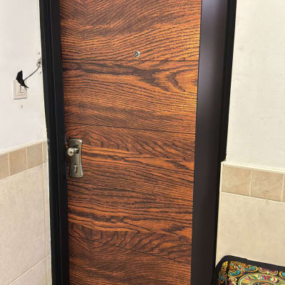 דלת עם ציפוי דמוי עץ ומסגרת מתכת שחורה
