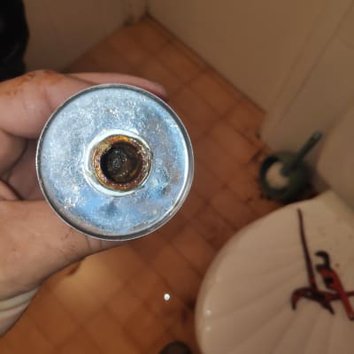 יד מחזיקה צינור חלוד ליד שירותים