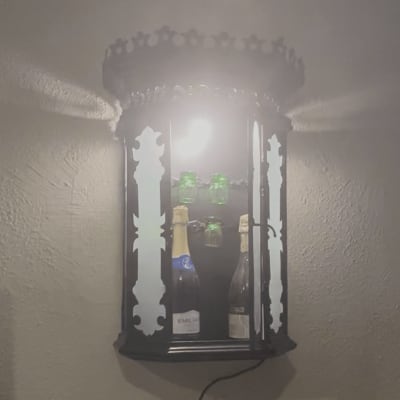 מנורה מעוצבת עם בקבוקי יין על קיר