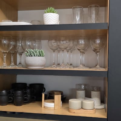 מדף עם כוסות יין, ספלים וצמחים דקורטיביים