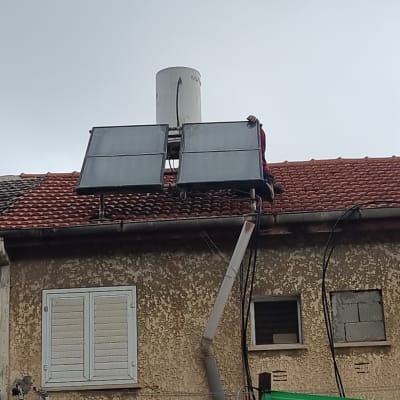 דוד שמש על גג עם קולטים סולאריים