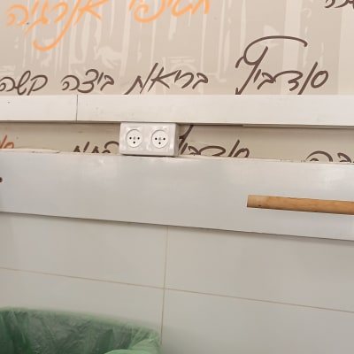 שקע חשמל על קיר עם כיתוב בעברית