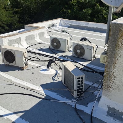 איטום גג עם חומר לבן סביב יחידות מיזוג אוויר.
