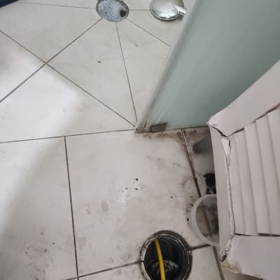 רצפה עם אריחים, חור ניקוז וצינור צהוב