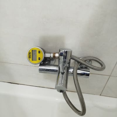 מד לחץ מים מחובר לברז בחדר אמבטיה