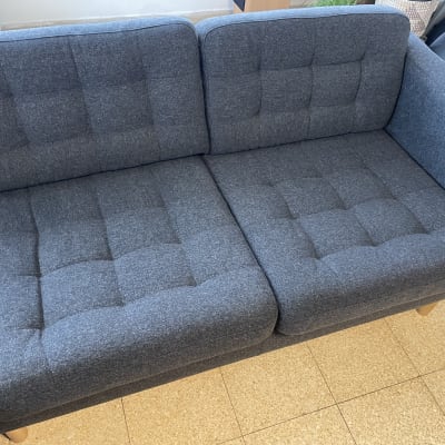 ספה אפורה עם ריפוד מרופד על רצפת אריחים