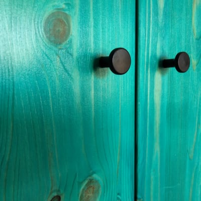 ידיות שחורות על דלתות עץ צבועות בטורקיז