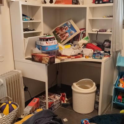 חדר מבולגן עם צעצועים, משחקי קופסה ובגדים מפוזרים