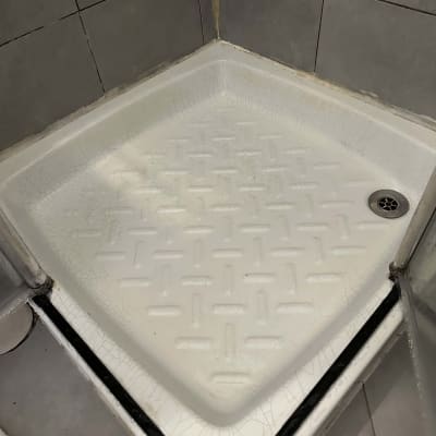 מגש מקלחת לבן עם אריחים אפורים מסביב