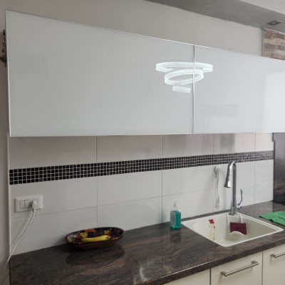 מטבח עם ארונות לבנים, כיור וברז נירוסטה