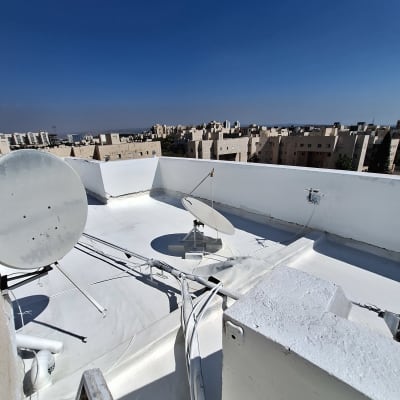 גג אטום עם צלחות לוויין וכבלים