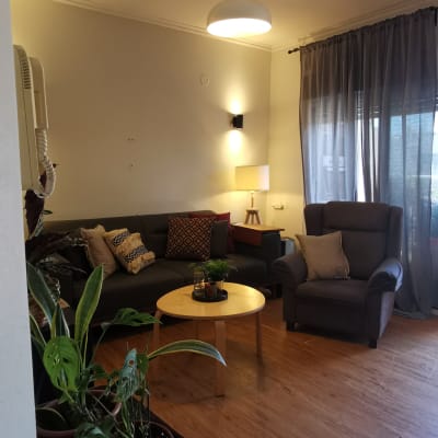 סלון מסודר עם צמחים, ספה ושולחן עגול