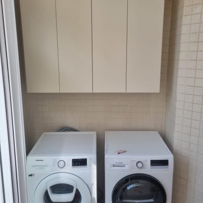 ארונות עץ תלויים מעל מכונות כביסה