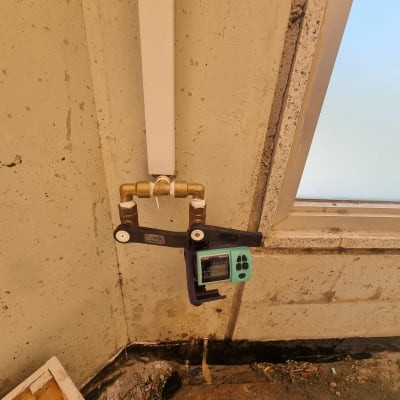 מד לחות מחובר לצינור מים על קיר בטון