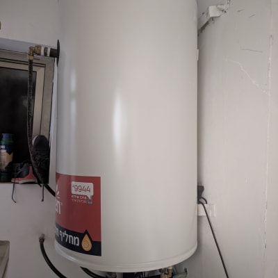 דוד שמש לבן עם מדבקה אדומה על הקיר