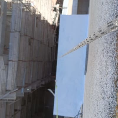 חבל תלוי מגובה לצד קיר בניין בבנייה