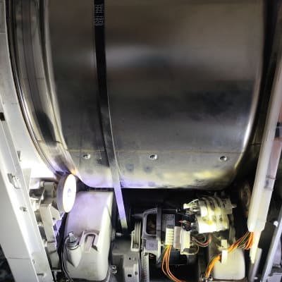 חלקים פנימיים של מכונת כביסה עם חוטים ומנוע