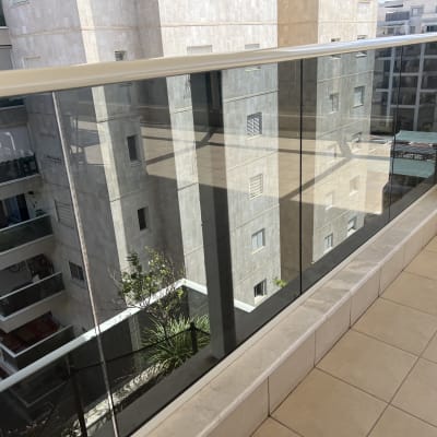 בקבוק חומר ניקוי על מרפסת עם מעקה זכוכית