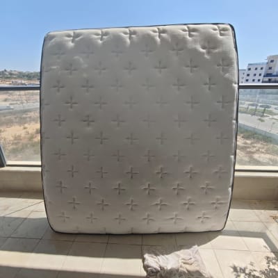 מזרן עומד על הרצפה עם סמרטוט לידו