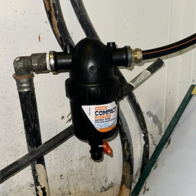 מסנן מים שחור מחובר לצינורות