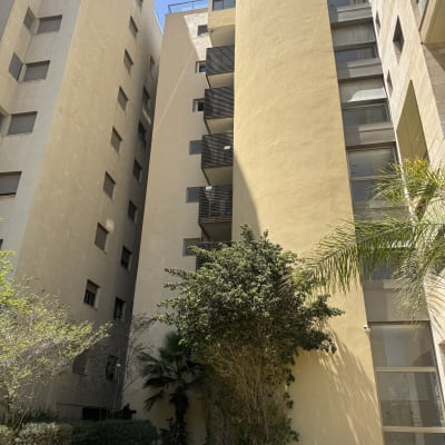 בניין מגורים עם עצים ודשא בחזית
