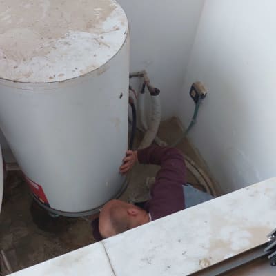 אדם מתקין דוד שמש עם צינורות מחוברים