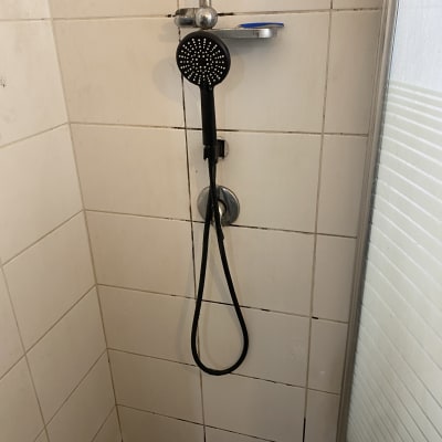 מקלחת עם ראש מקלחת וצינור גמיש על הרצפה