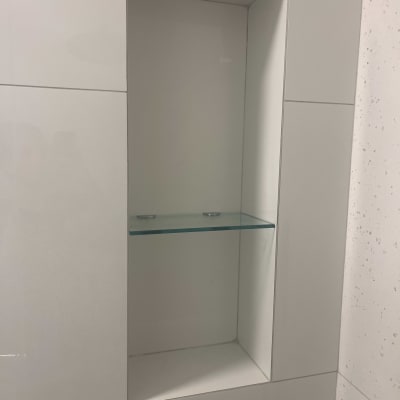 מדף זכוכית בתוך נישה בקיר לבן