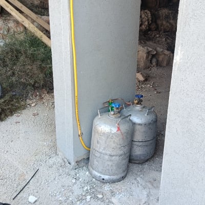 שני בלוני גז ליד קיר עם צינור צהוב