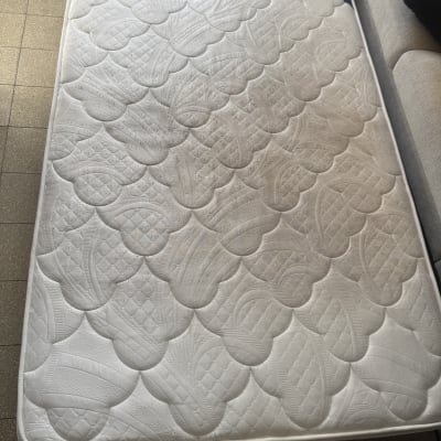 מזרן על רצפה ליד ספה, מתאים לניקוי ספות.