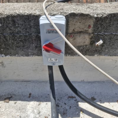 מתג חשמלי עם כבל על קיר בטון