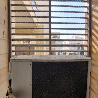 רשת מתכת על חלון למניעת כניסת יונים