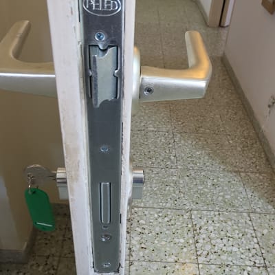 מנגנון מנעול וידית מותקנים בדלת ממ"ד עם צילינדר ומפתח