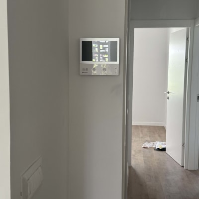 אינטרקום עם מסך מגע מותקן על קיר לבן