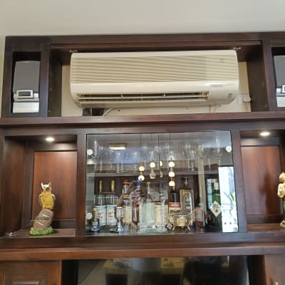 מזגן מותקן על מדף עץ עם חפצי נוי