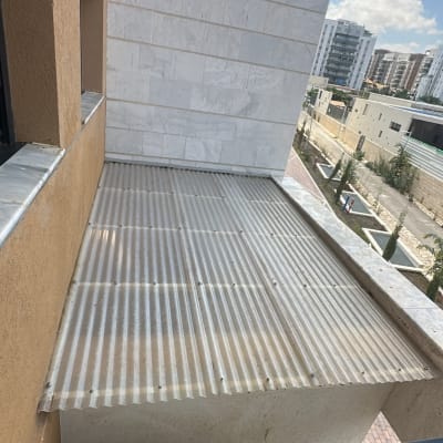 גג מרפסת עם קיר לבנים ונוף עירוני