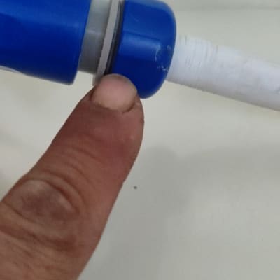 אצבע מצביעה על חיבור צינור כחול ולבן