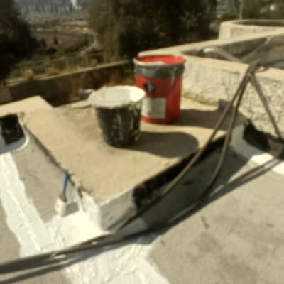 דלי צבע וכלים על גג במהלך עבודה